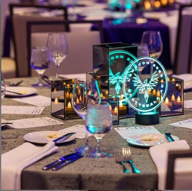 the table is set with glasses, plates and silverware for an elegant dinner party