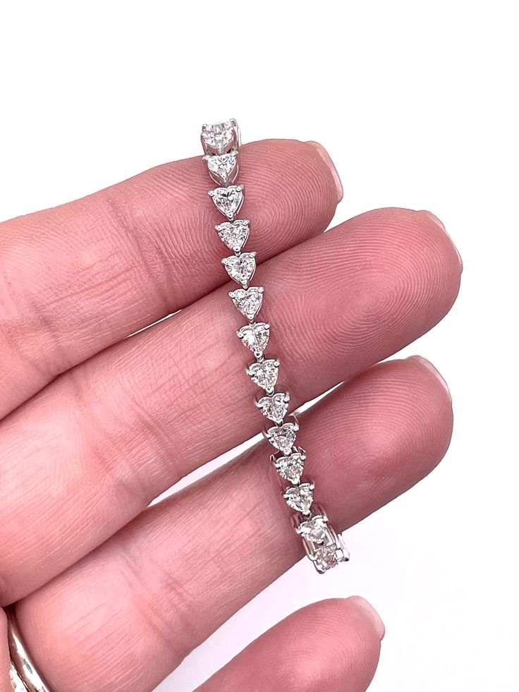 Elevate your wrist game with our exquisite 6 CTW Heart Lab-Grown Diamond Bracelet in 14K White Gold. Featuring stunning VS clarity, F color diamonds, this piece exudes elegance and sophistication. Perfect for adding a touch of luxury to any outfit, it's a statement piece you'll cherish forever. Treat yourself or a loved one to this sparkling beauty today! Customization is our specialty! As direct gemstone and diamond brokers, along with being jewelry designers, we're thrilled to offer personaliz Elegant Diamond Heart Bracelet With Brilliant Cut, Diamond Heart Cut Tennis Bracelet With Brilliant Cut, Luxury Heart Cut Cubic Zirconia Tennis Bracelet, Heart Cut Diamond Tennis Bracelet With Accents, White Gold Diamond Heart Bracelet For Wedding, Fine Jewelry White Gold Heart Bracelet With Cubic Zirconia, Heart Cut Diamond Tennis Bracelet With Diamond Accents, Luxury Cubic Zirconia Heart Cut Tennis Bracelet, Diamond Heart Jubilee Bracelet