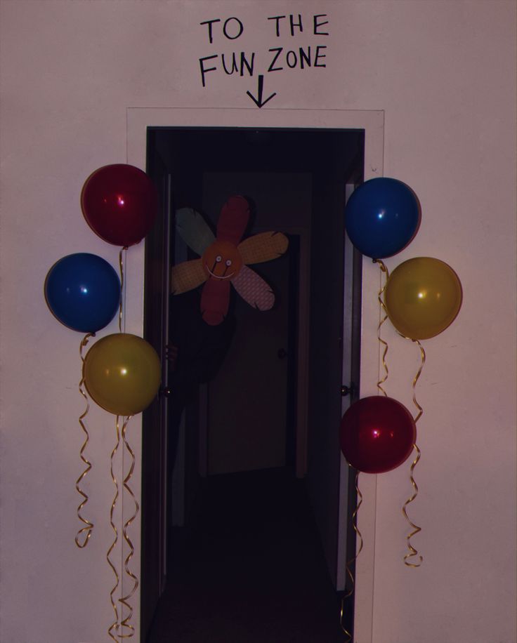 the door to the fun zone is decorated with balloons and a propeller shaped pinwheel