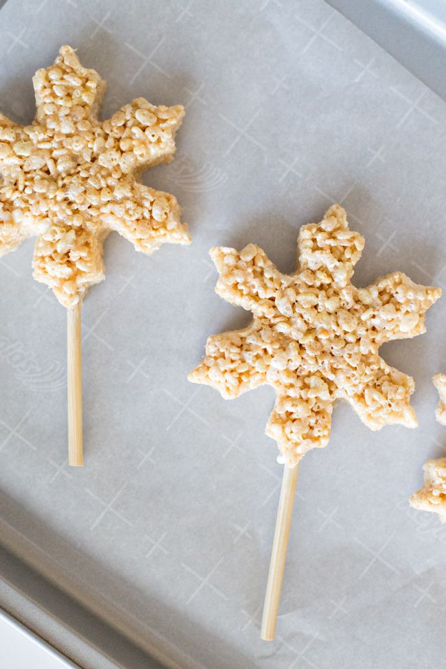 three cookies shaped like snowflakes sitting on top of a pan