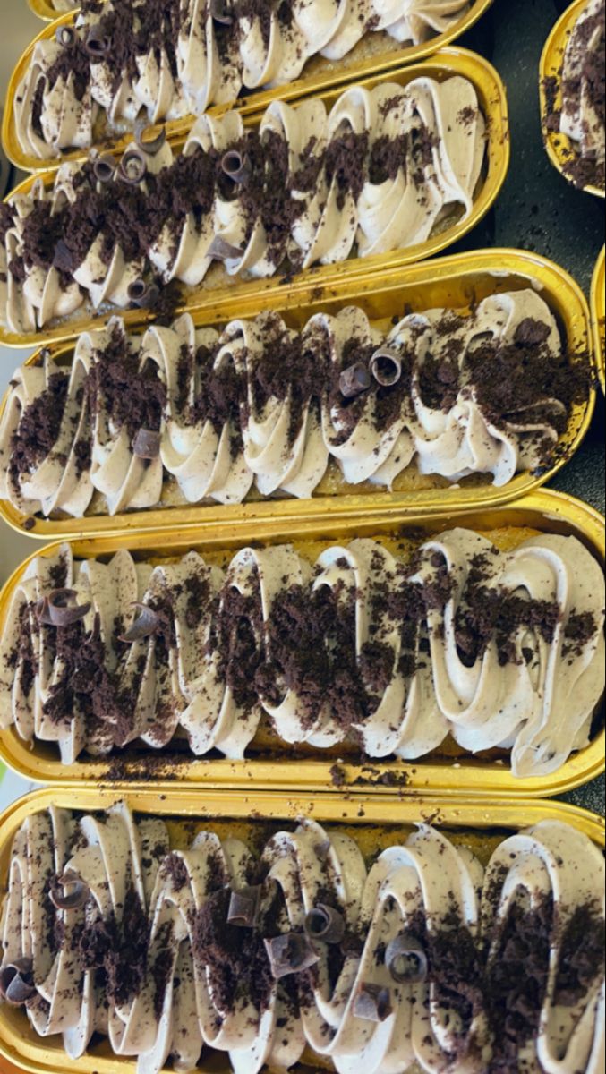 several trays filled with ice cream and chocolate chip cookie dough covered in white icing