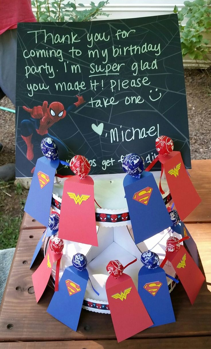 a birthday cake made to look like supermans and his name is written on it