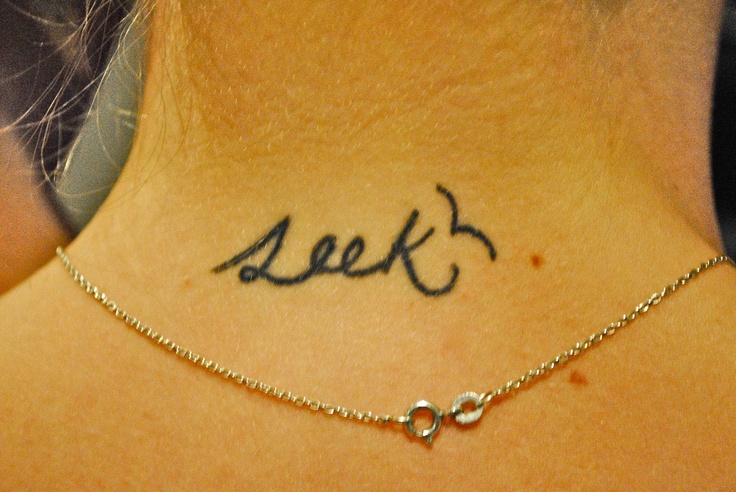 a woman's back neck with the word seek written on her left side ribcage