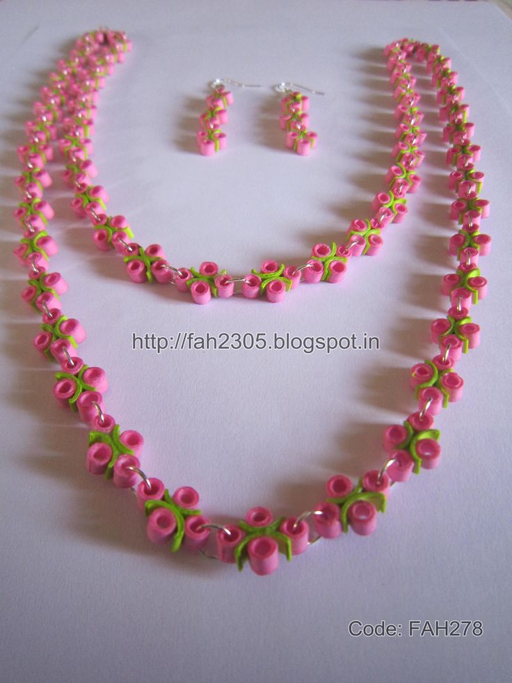 a necklace and earring set with pink flowers