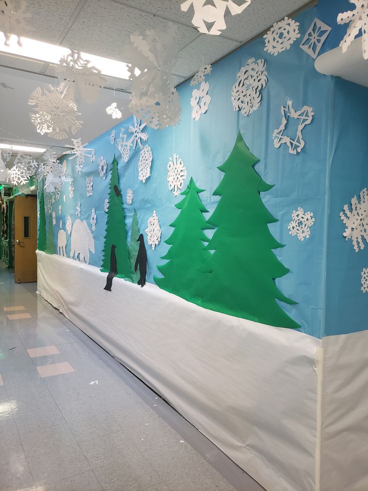 an office decorated for christmas with snowflakes and trees on the wall in front of it