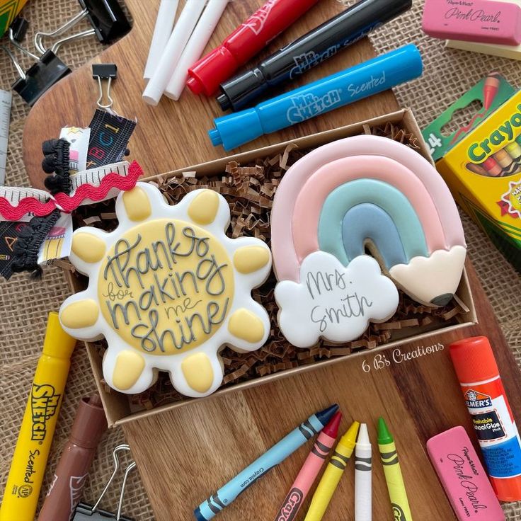 there are many different items on the table including markers, crayons and cookies