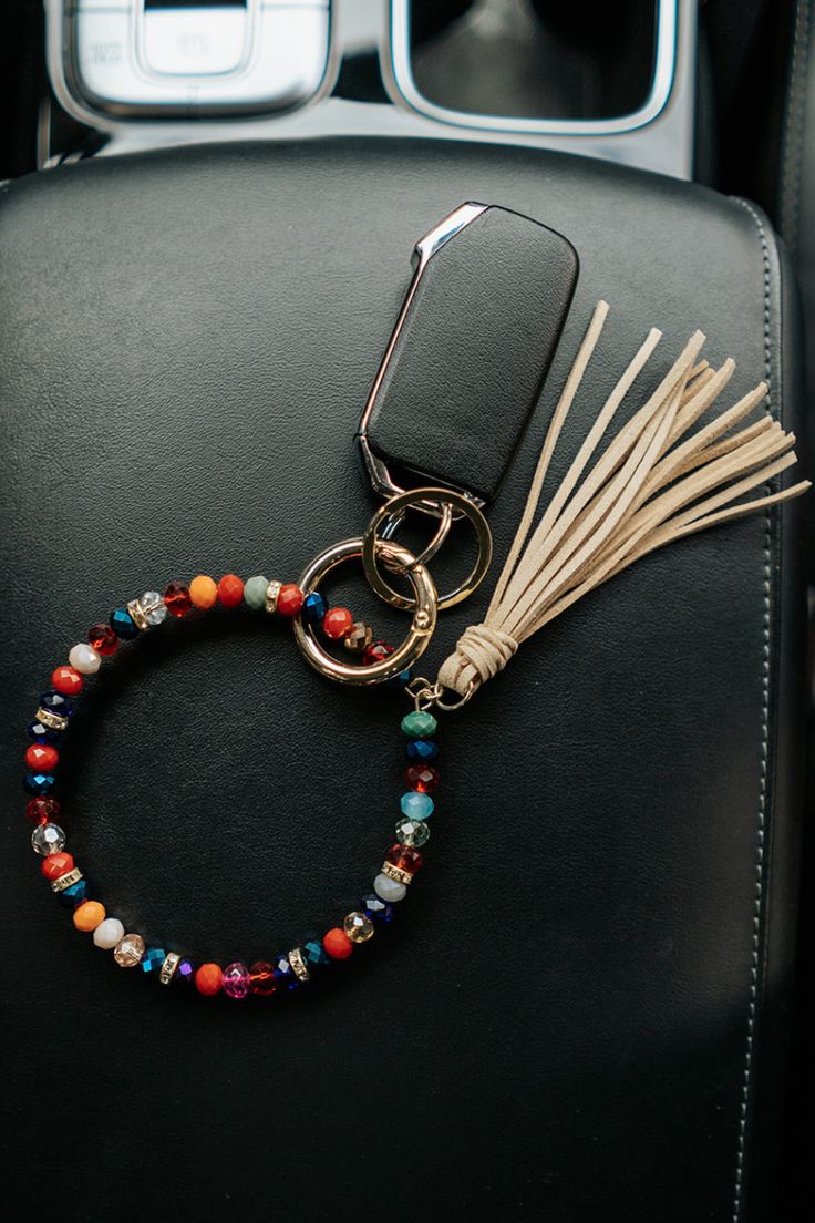 a car keychain that has some beads on it and a tassel attached to it