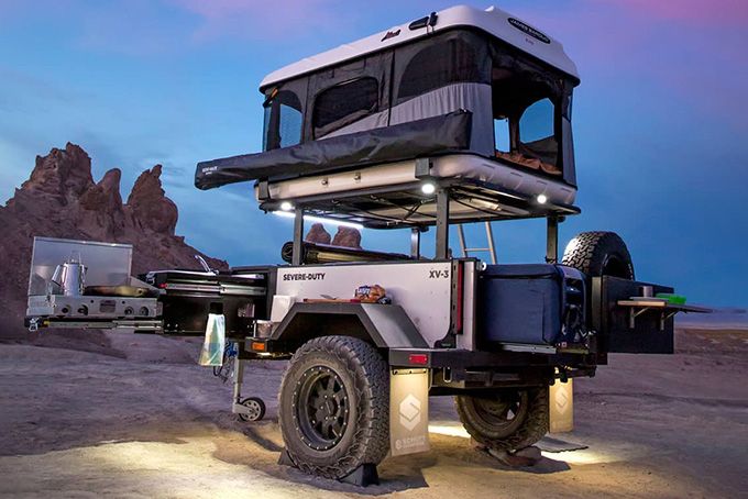 an off - road vehicle is parked in the desert at night with its lights on