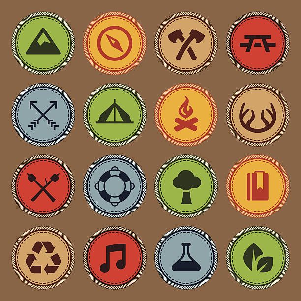 different colored badges with symbols for camping and hiking in the woods, on a brown background