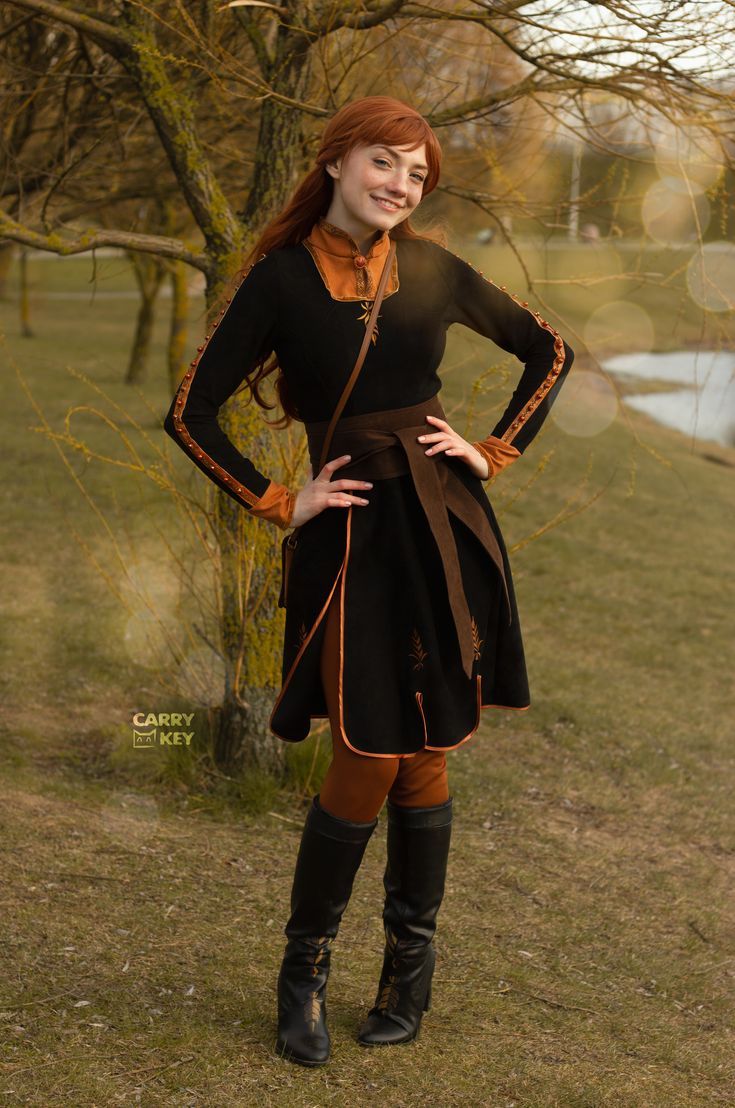 a woman is standing in the grass with her hands on her hips and wearing boots