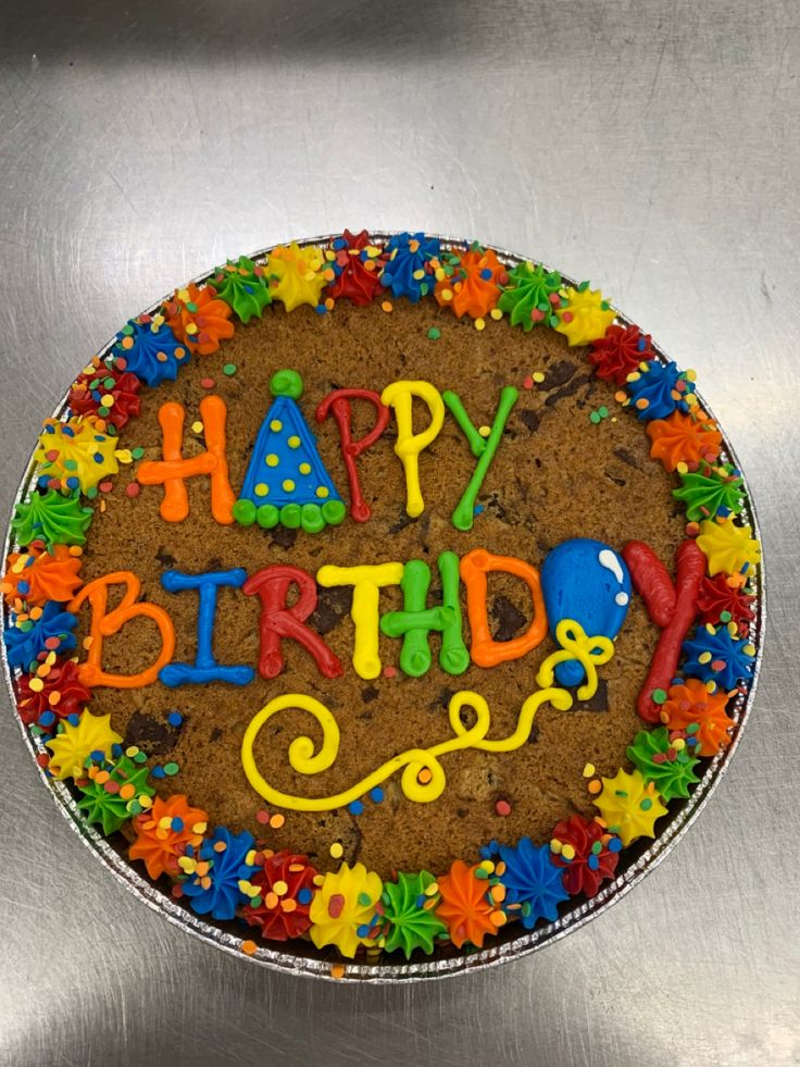 a birthday cake with the words happy birthday written in colorful frosting on top of it