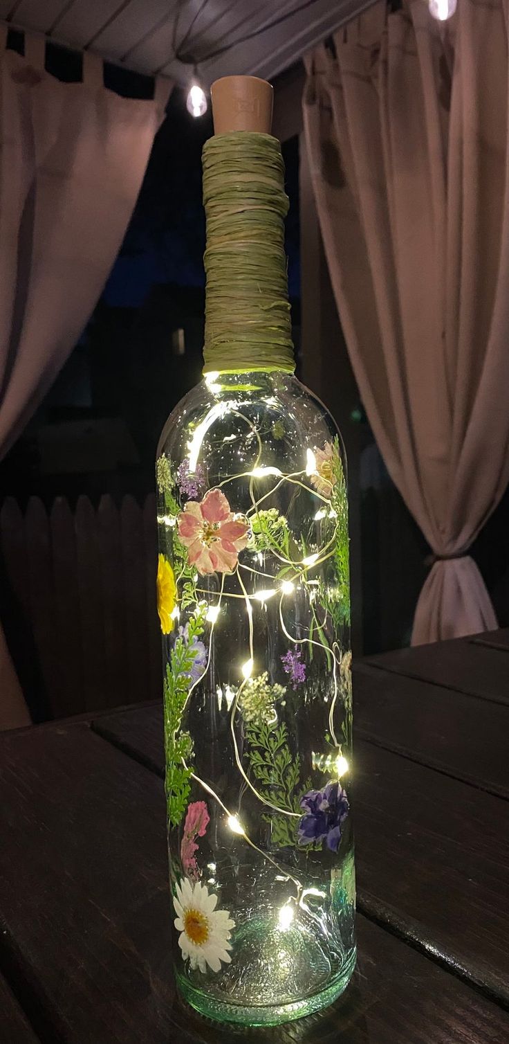 a glass bottle with lights in it sitting on a table