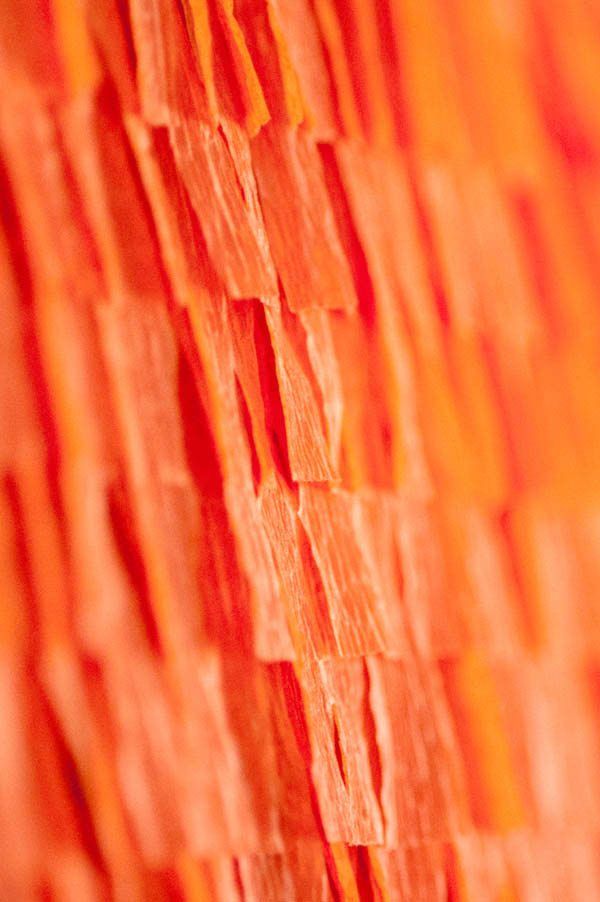 an orange piece of paper that has been placed on the side of a wooden wall