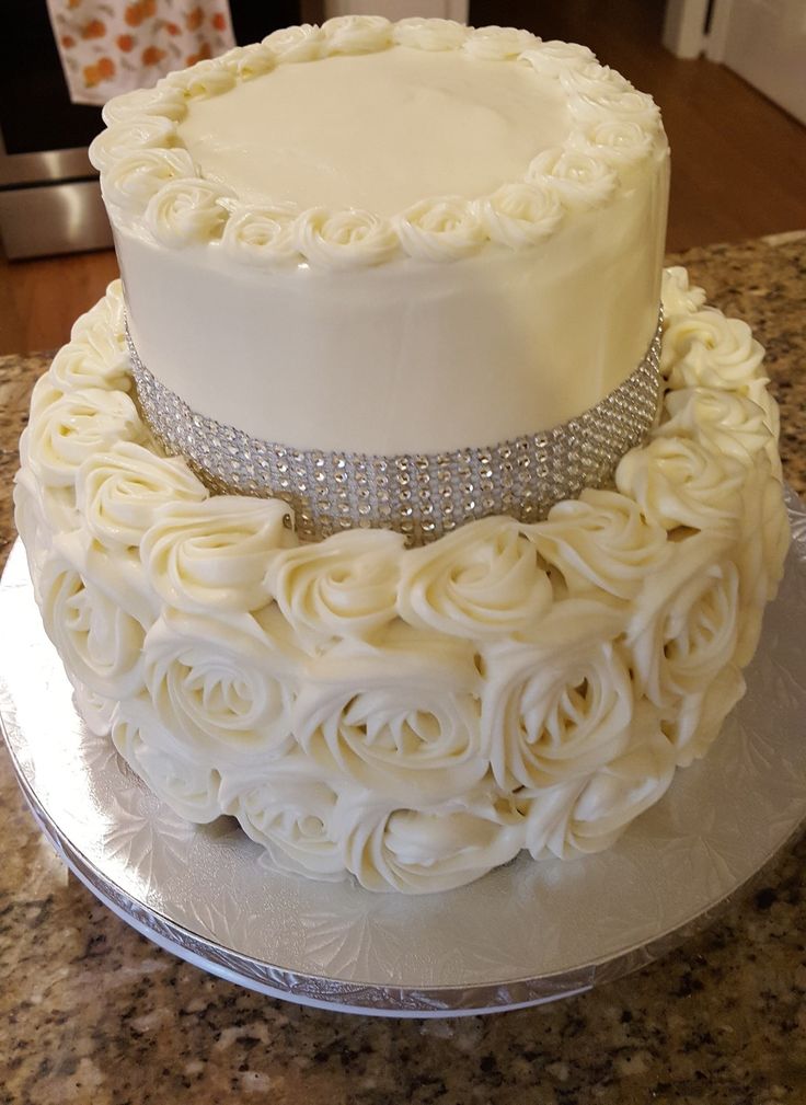 two tiered wedding cake with white frosting roses