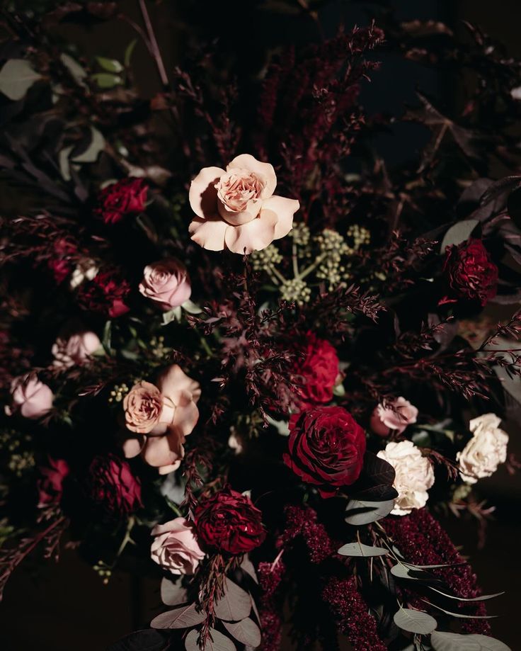 a vase filled with lots of flowers on top of a table