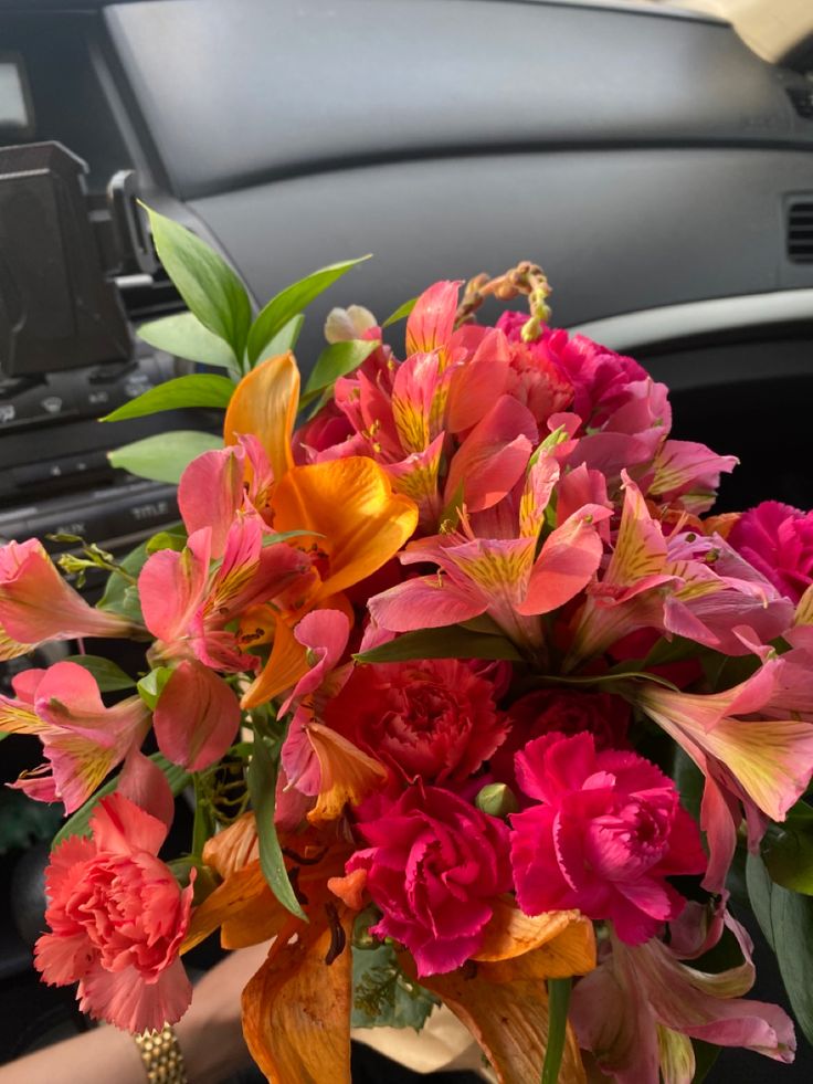 a bouquet of flowers sitting on the dashboard of a car