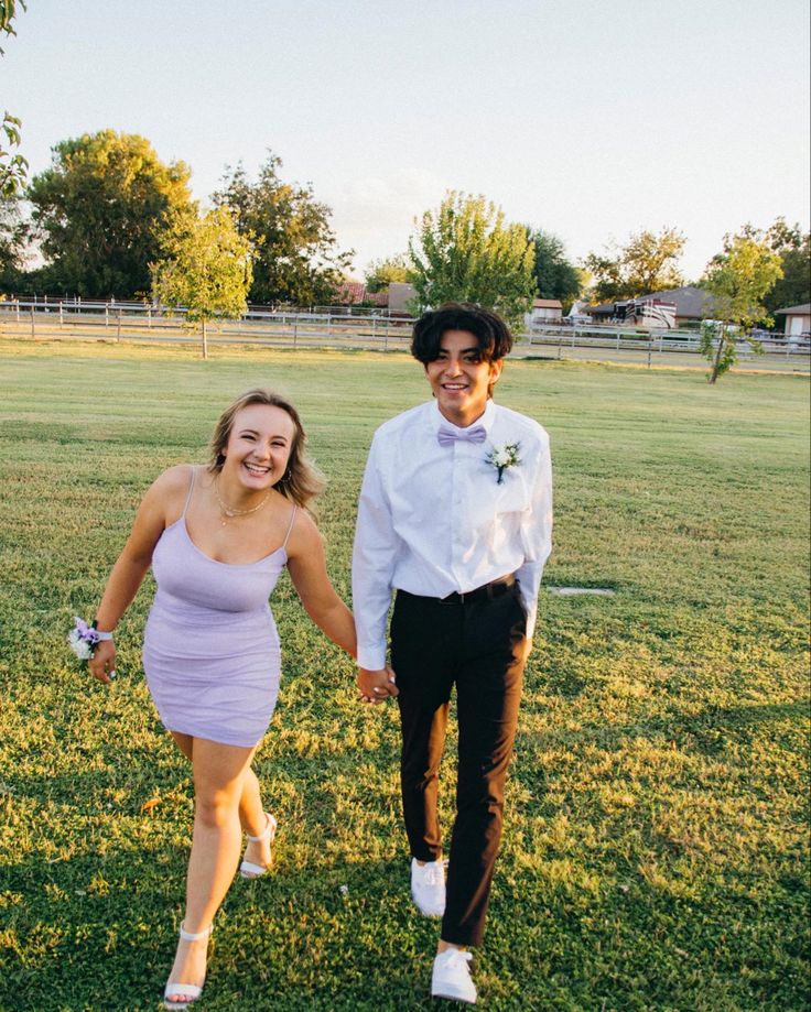 a man and woman are walking in the grass