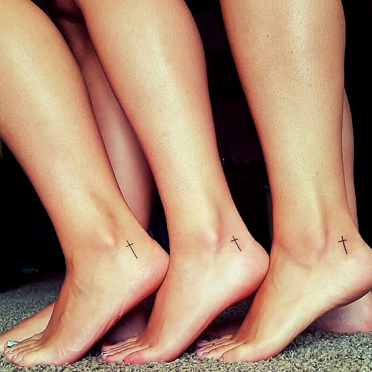 three people with cross tattoos on their feet