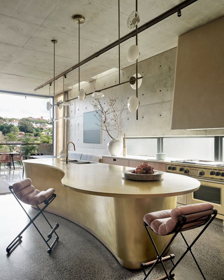 a kitchen with an island and chairs in front of the counter top, overlooking a city