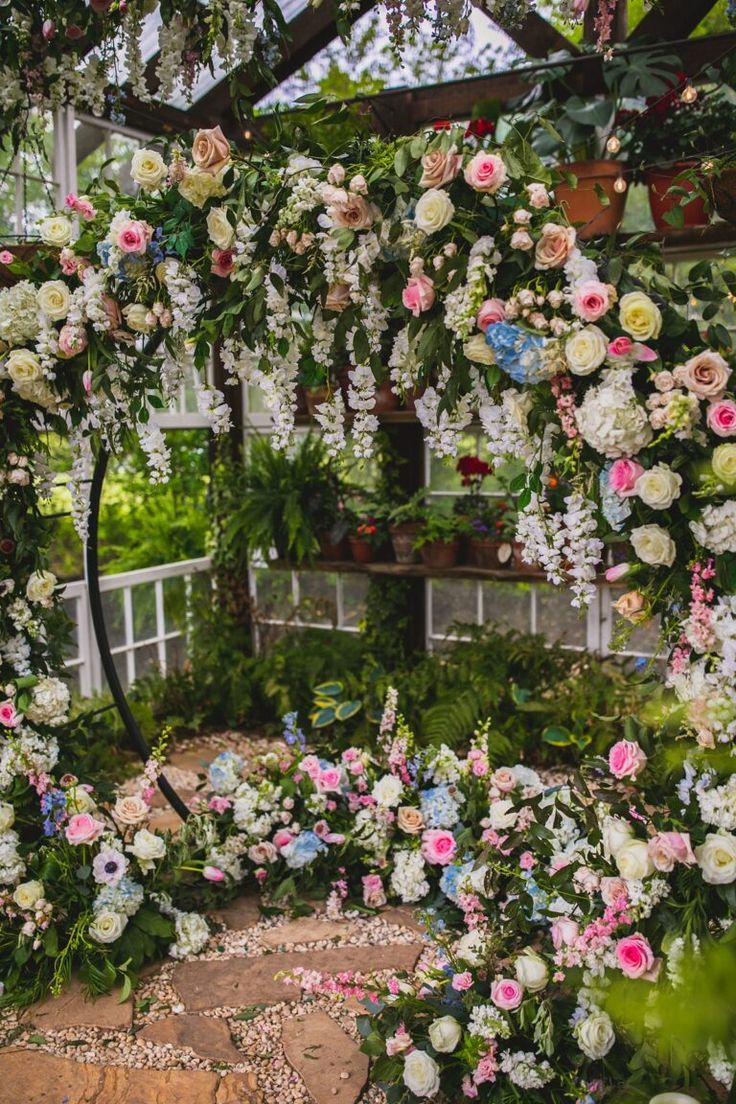 an arch covered in lots of white and pink flowers