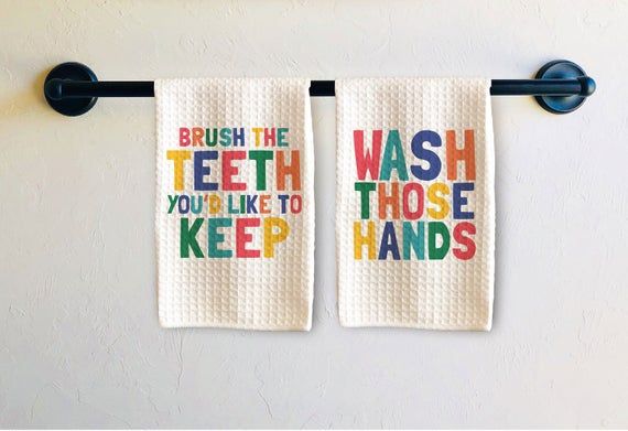 two bathroom towels hanging on the wall next to each other with words that say brush the teeth you're like to keep hands