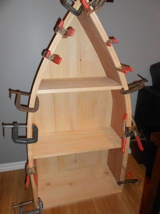 a wooden shelf with many tools on top of it in the corner of a room