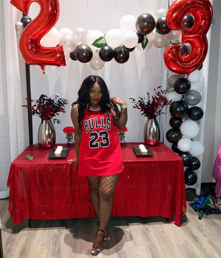 a woman standing in front of a table with balloons