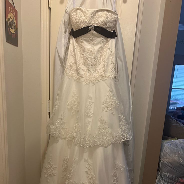 a wedding dress hanging on a door