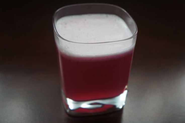 a glass filled with liquid sitting on top of a table