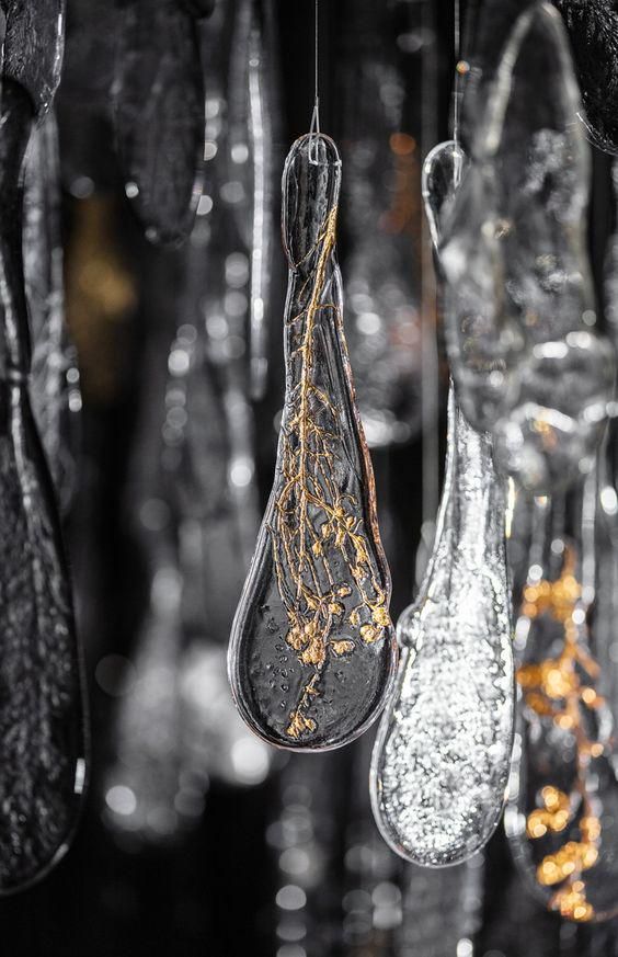 some glass hanging from the ceiling in a room with lights and decorations on it's sides