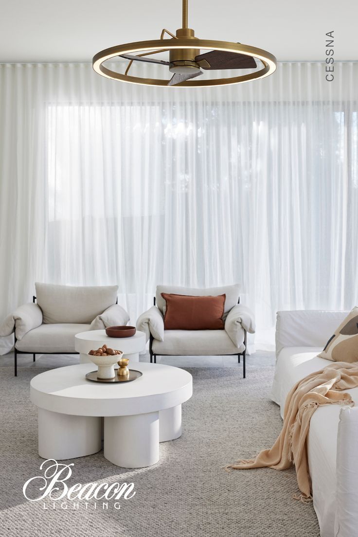 a living room with white furniture and curtains