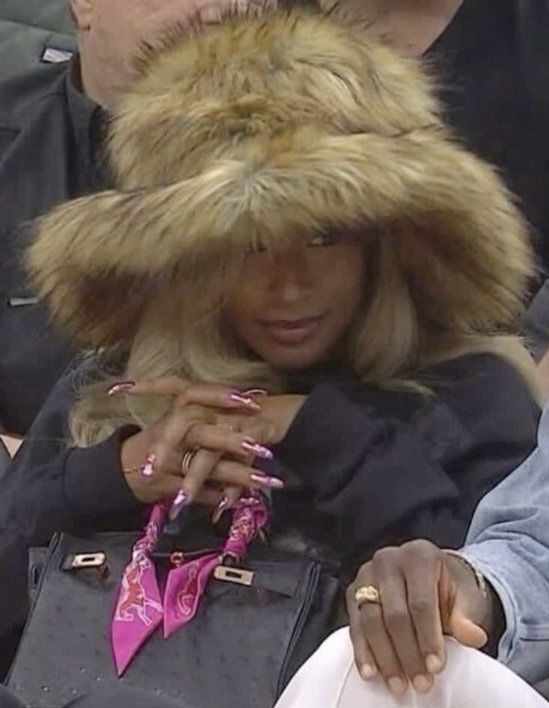 a woman wearing a fur hat and holding a cell phone