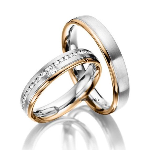 two gold and white wedding rings with diamonds on each side, in the shape of an inter