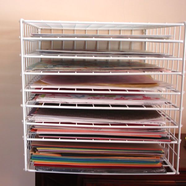 a stack of papers sitting on top of a white shelf