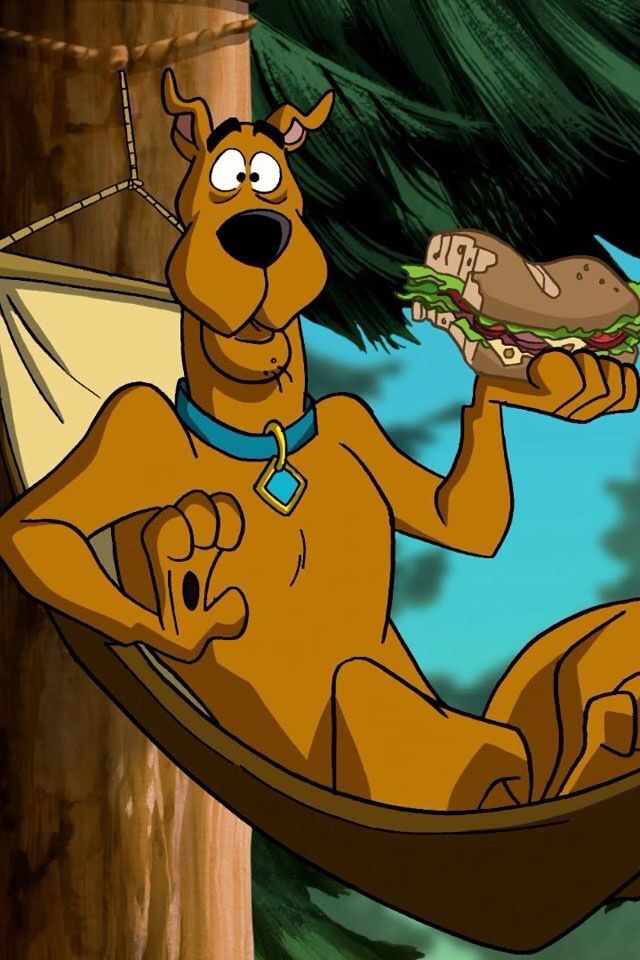 scooby holding a sandwich in his hand while sitting on a hammock