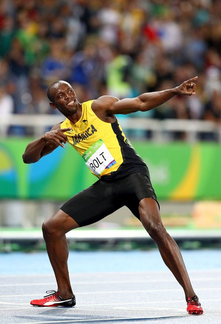 a man in a yellow shirt and black shorts is doing a trick on the track