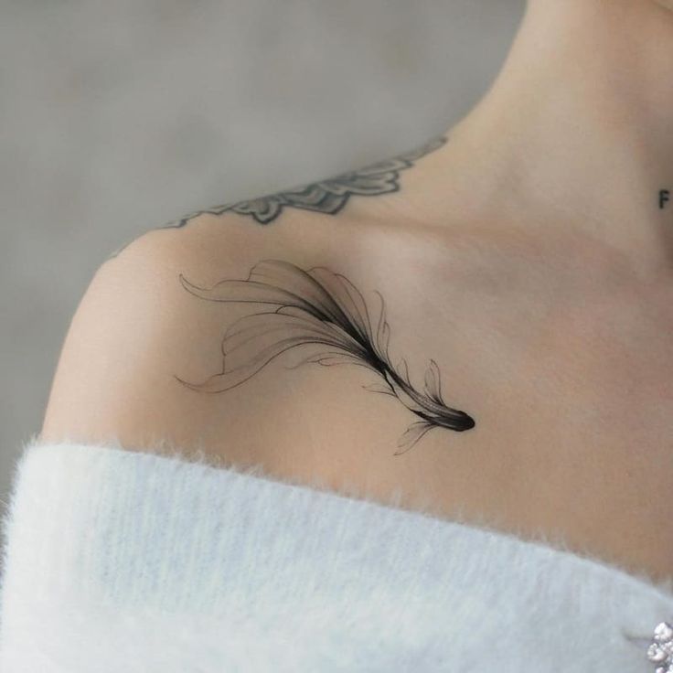 a woman with a feather tattoo on her shoulder