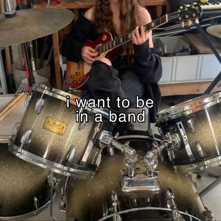 a woman sitting on top of a drum kit