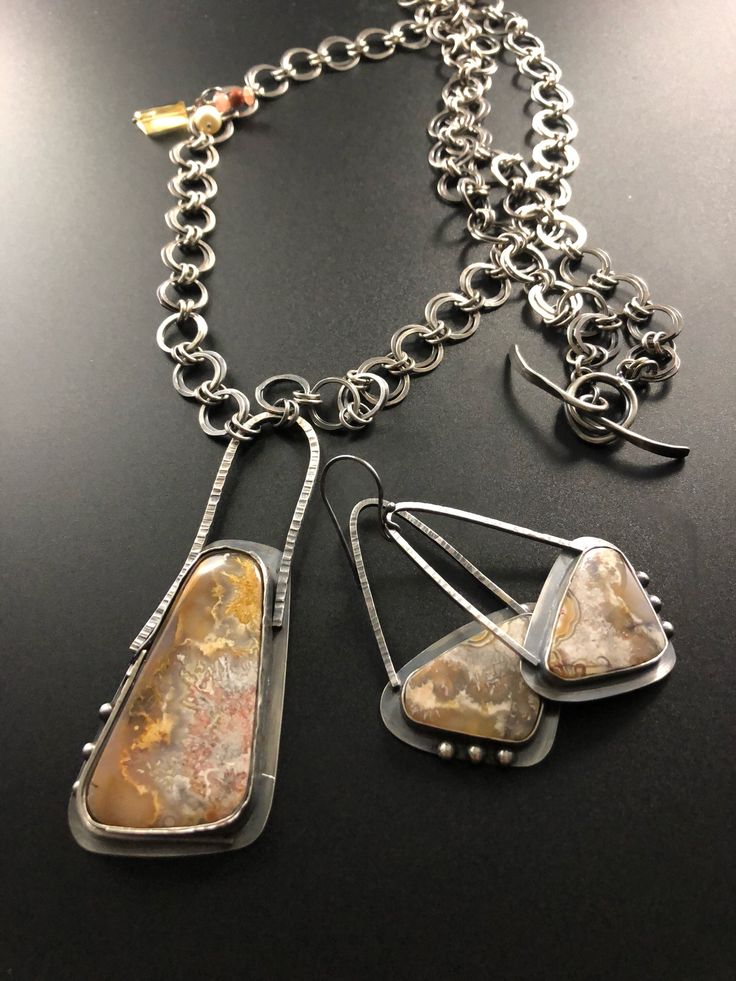 This beautiful necklace is accentuated with a lovely 'Crazy Lace Agate' stone set in silver. Layers of textured silver wrap around the setting and great soft earth tones flow throughout the stone. Hanging from a hammered round linked chain and complimented by Golden Citrine, Sunstone and a Freshwater Pearl that dangle off one side of the chain. A handmade toggle is used for the chain closure.  Earrings sold! Silver Sterling Silver Jewelry, Earthy Sterling Silver Jewelry, Sterling Silver Jewelry With Natural Stones, Sterling Silver Jewelry With Natural Stones In Unique Shapes, Contemporary Silver Jewelry With Gemstone, Sterling Silver Jewelry With Natural Stones In Freeform, Artisan Silver Freeform Jewelry, Hand Forged Agate Pendant Necklace, Hand-forged Agate Pendant Necklace