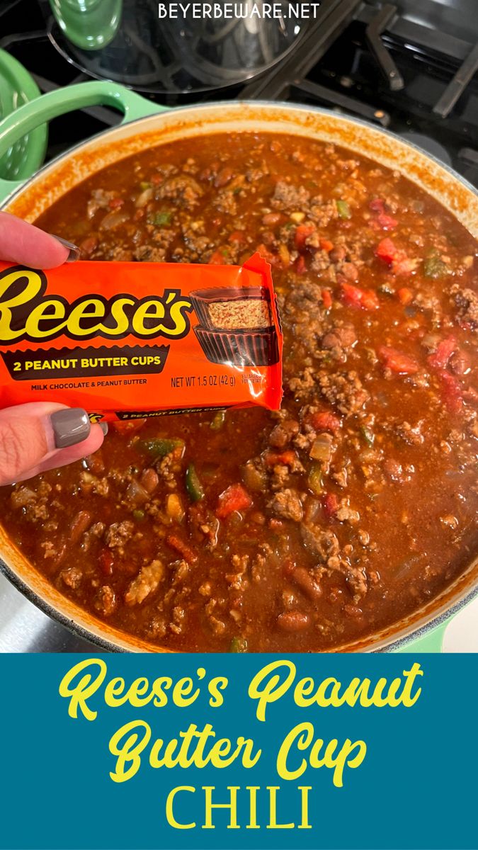 a hand holding a reese's peanut butter cup chili bar over a pot of chili