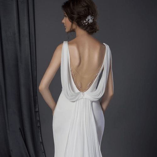 a woman in a white dress is standing with her back to the camera