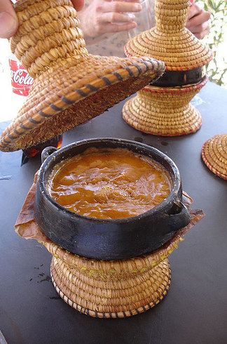 a person holding a basket over a bowl of food