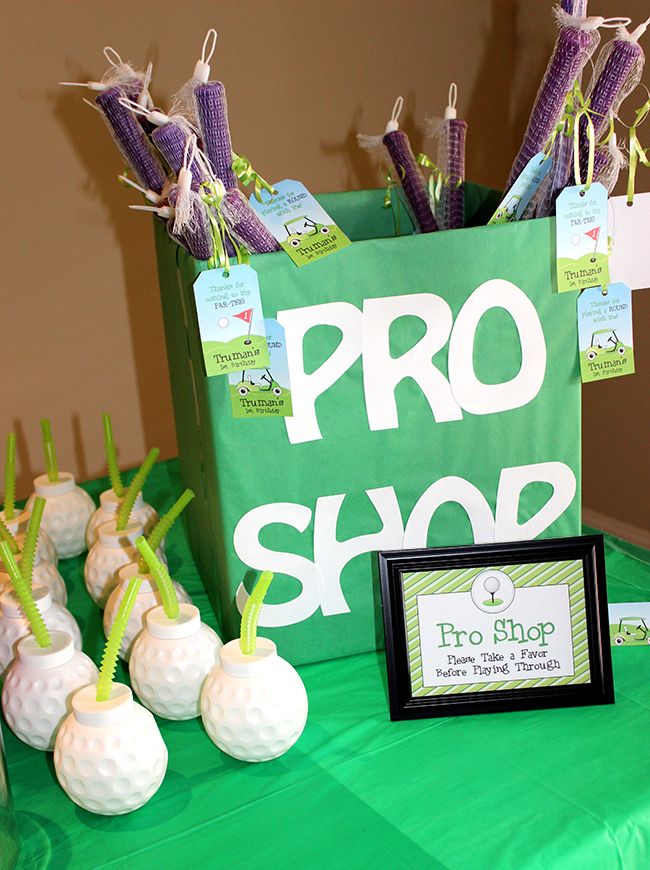 a green table topped with lots of white golf balls next to a sign that says pro shop