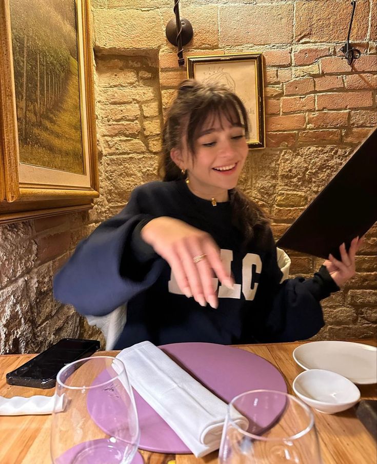 a woman sitting at a table with plates and napkins