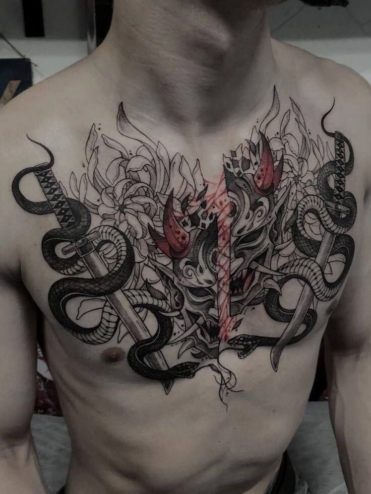 a man's chest with tattoos on it and an image of a snake in the middle