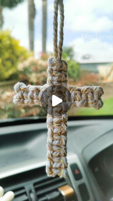 a car dashboard with a cross made out of rope