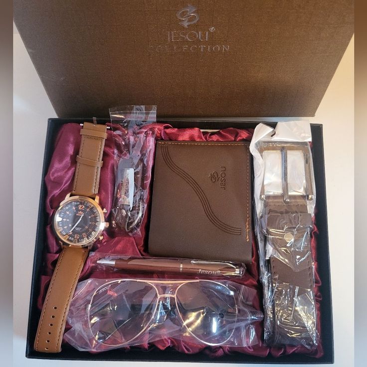 a watch, pen and glasses in a box