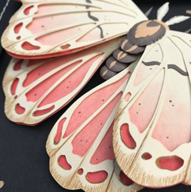 a close up of a butterfly shaped object on a black surface with other objects around it