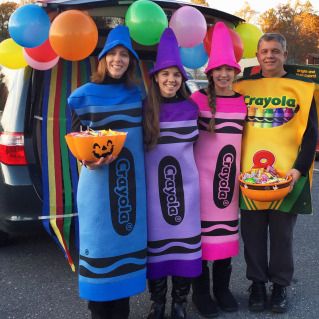 three people dressed in costumes standing next to a van with balloons and food on it