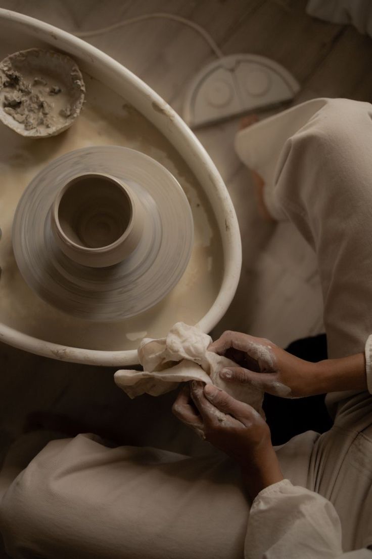 a woman is working on a pottery wheel